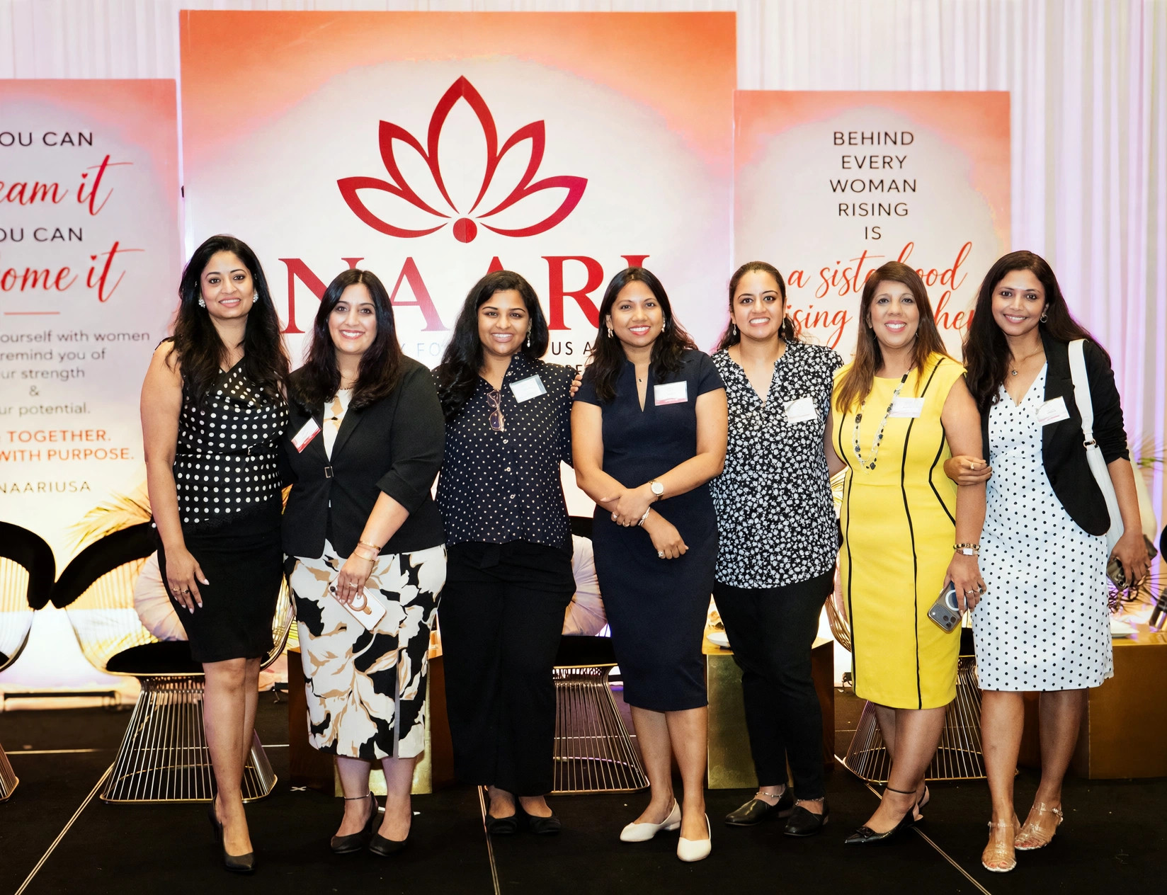 Seven women gathered at the NAARI stage backdrop