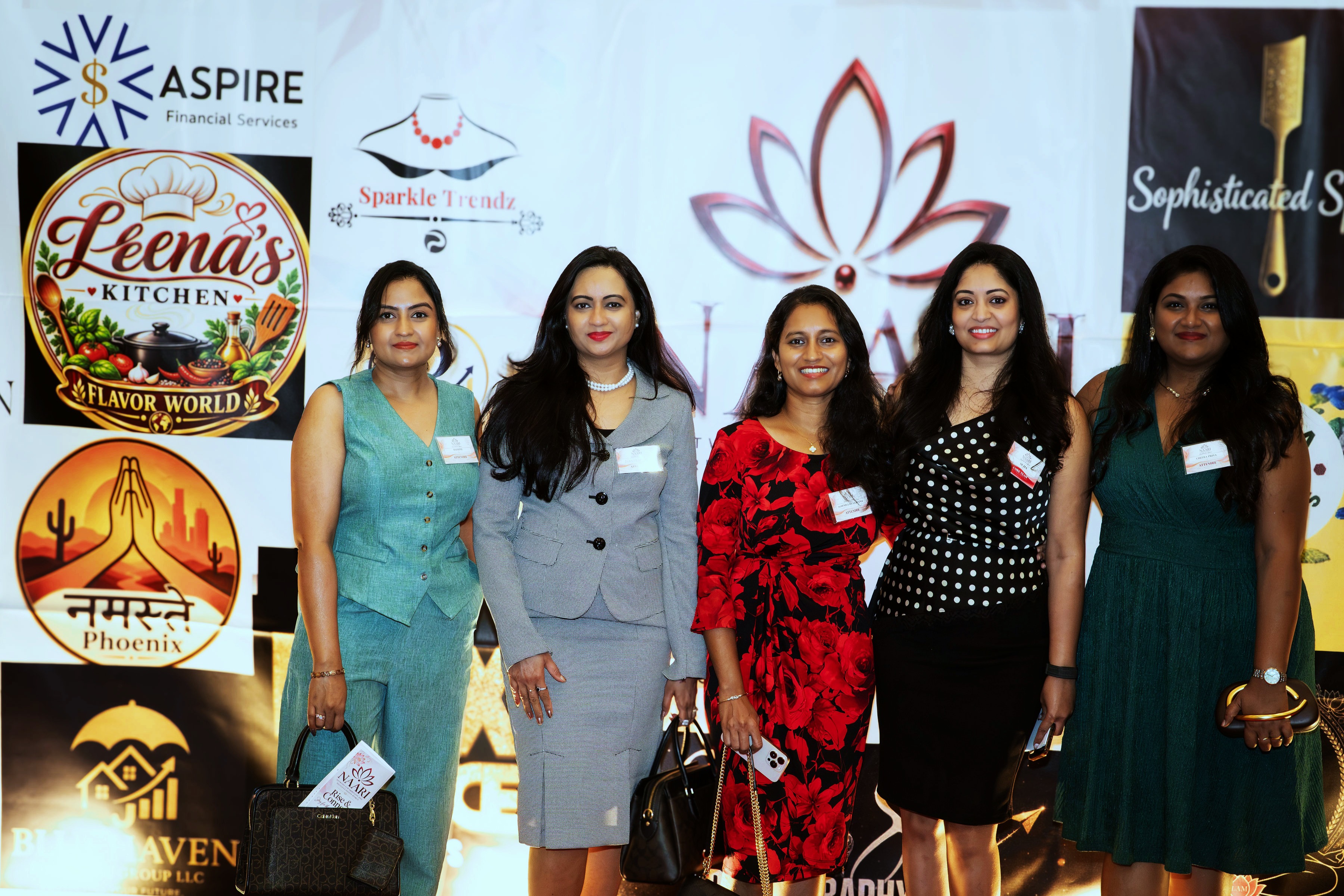 Eight women together at the sponsor step-and-repeat backdrop